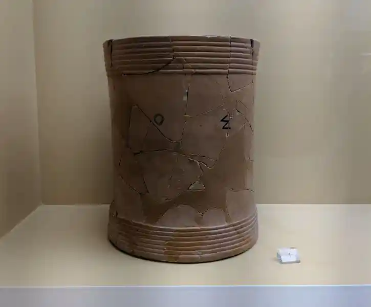 Large cylindrical terracotta dry measure vessel with incised Greek letters and horizontal ribbed bands marking official standard capaci